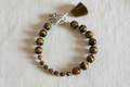 Tiger's eye breathwork bracelet on cream cotton background