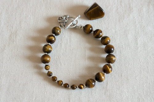 Tiger's eye breathwork bracelet on cream cotton background